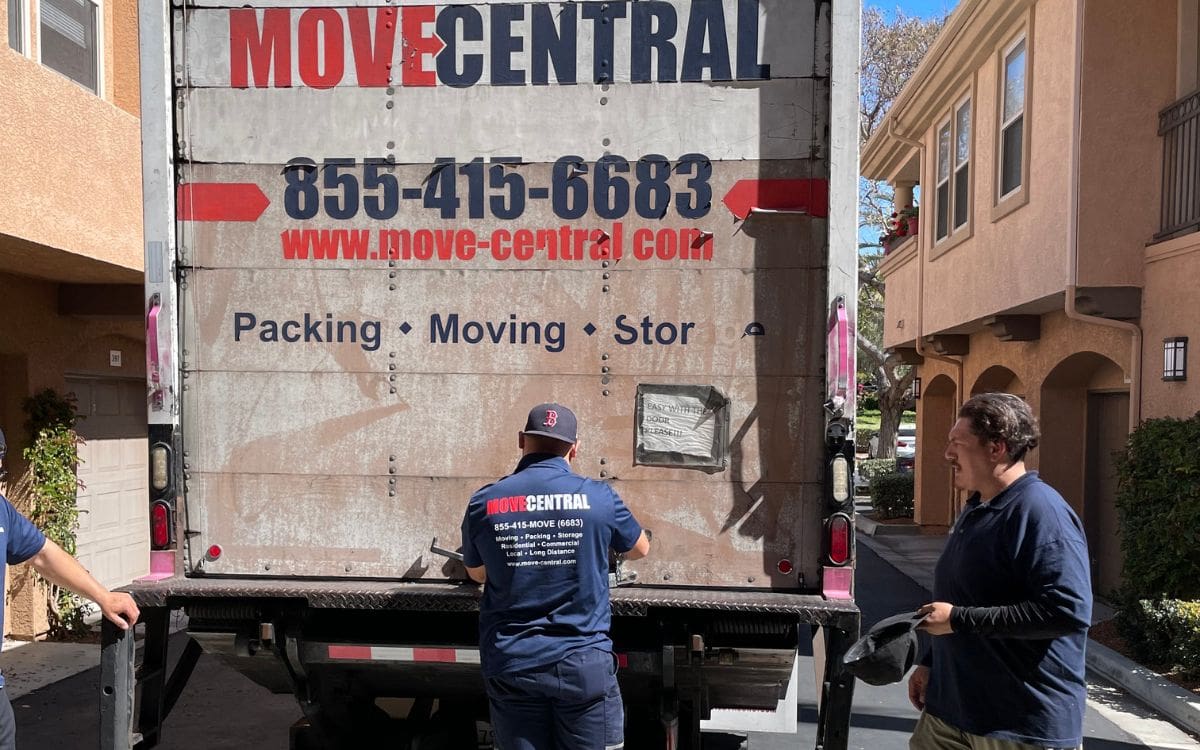 Movers in navy Move Central shirts working beside a branded moving truck
