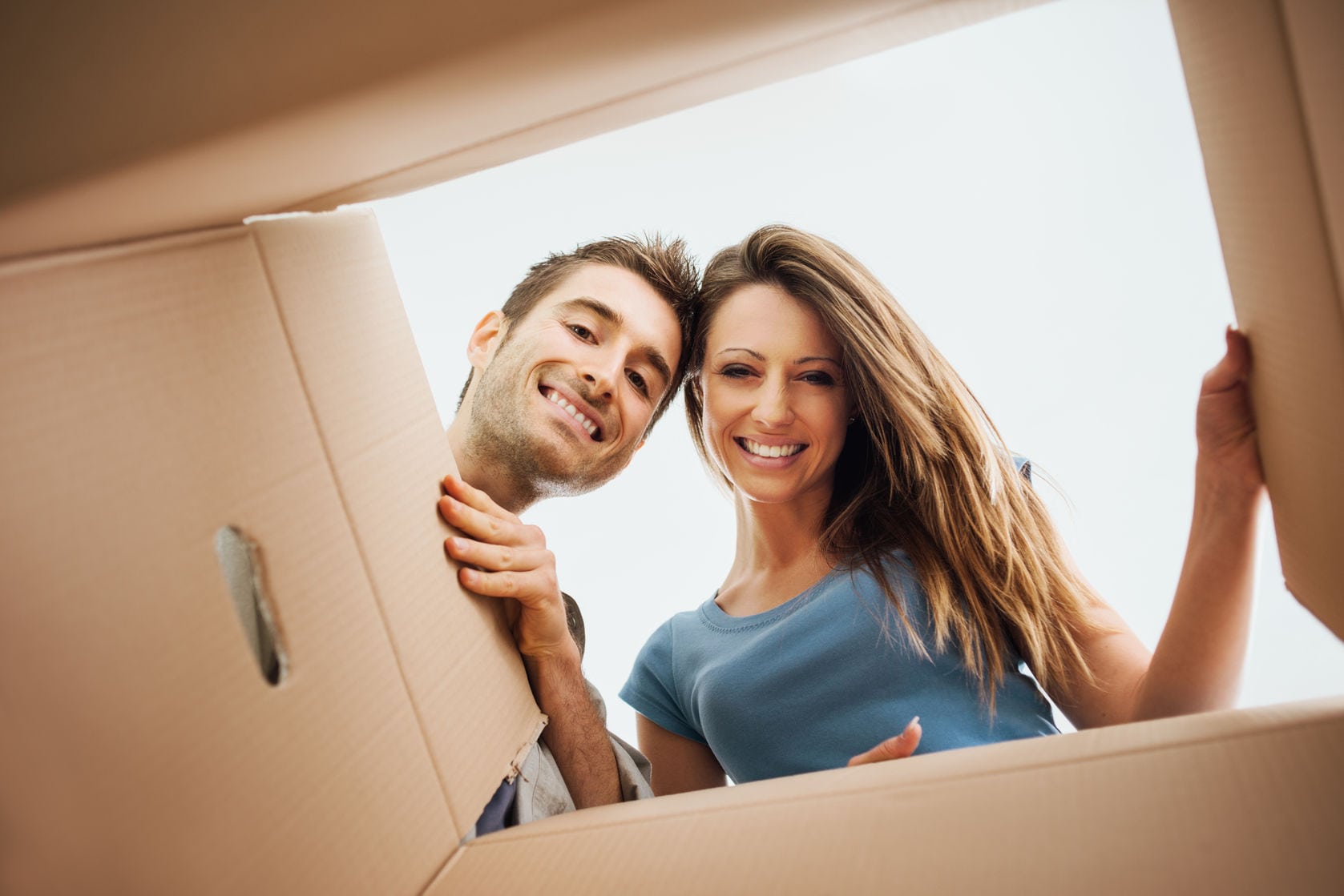 couple looks into a moving box smiling