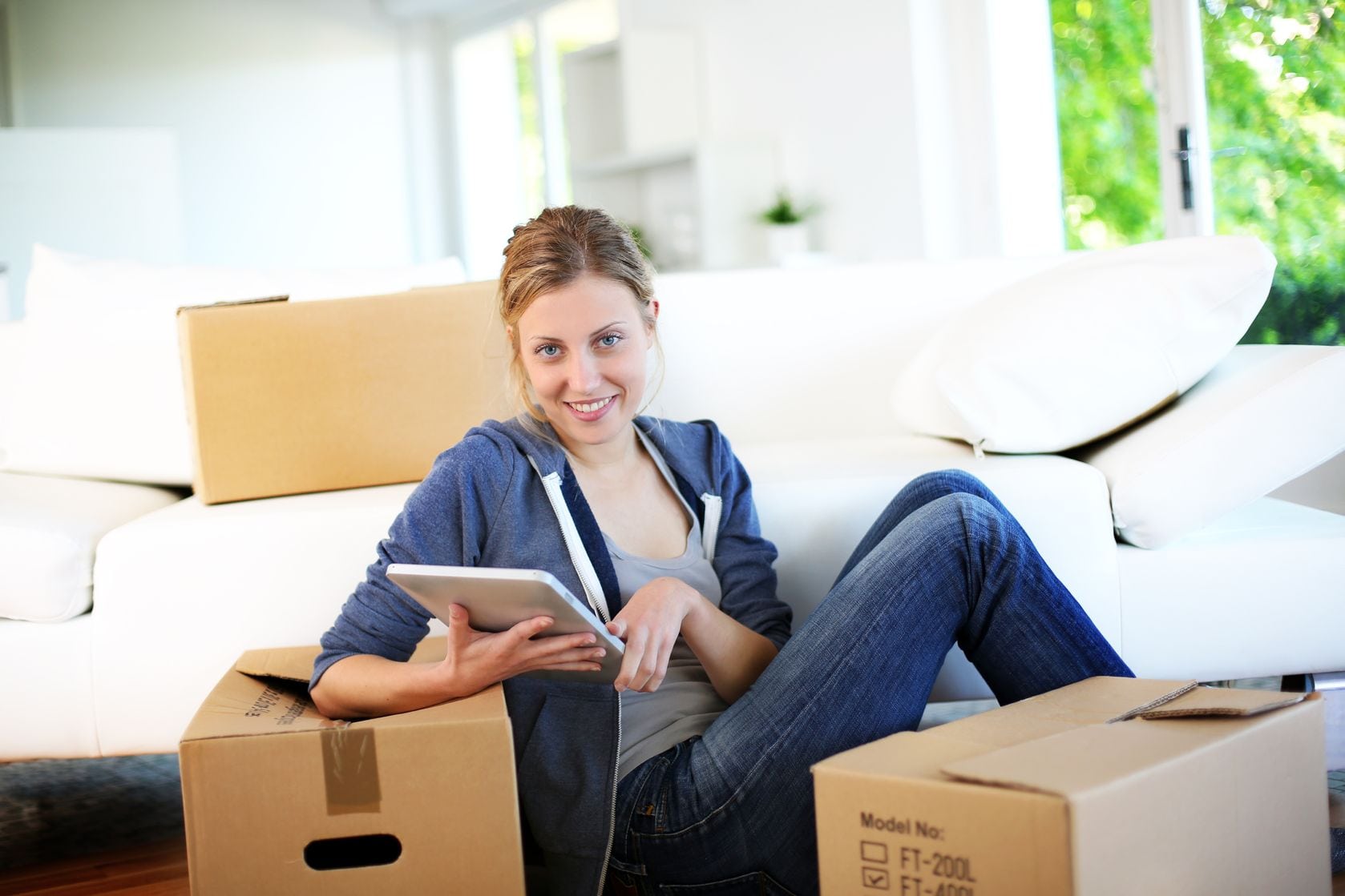 woman reading tablet with moving boxes around