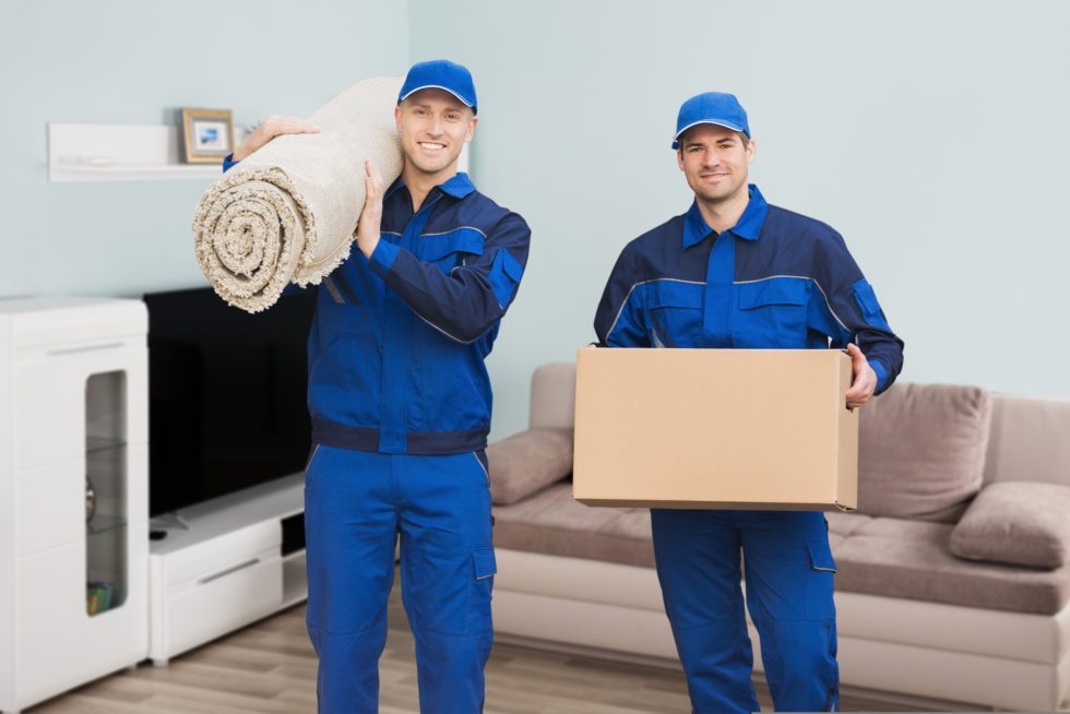 moving crew holding a box and a rug