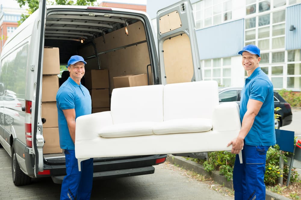moving crew holding white couch