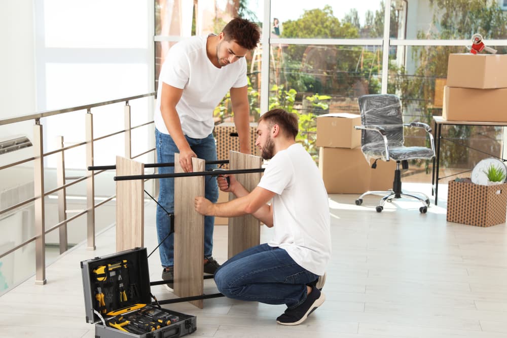 men taking apart furniture