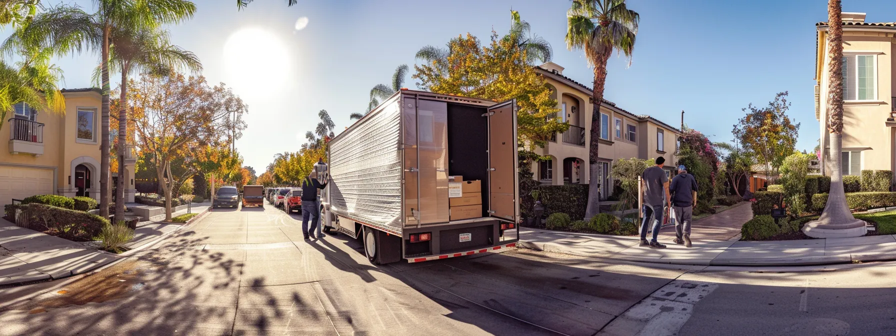 a team of experienced movers carefully loading shrink-wrapped furniture into a moving truck in a sunny san diego neighborhood.