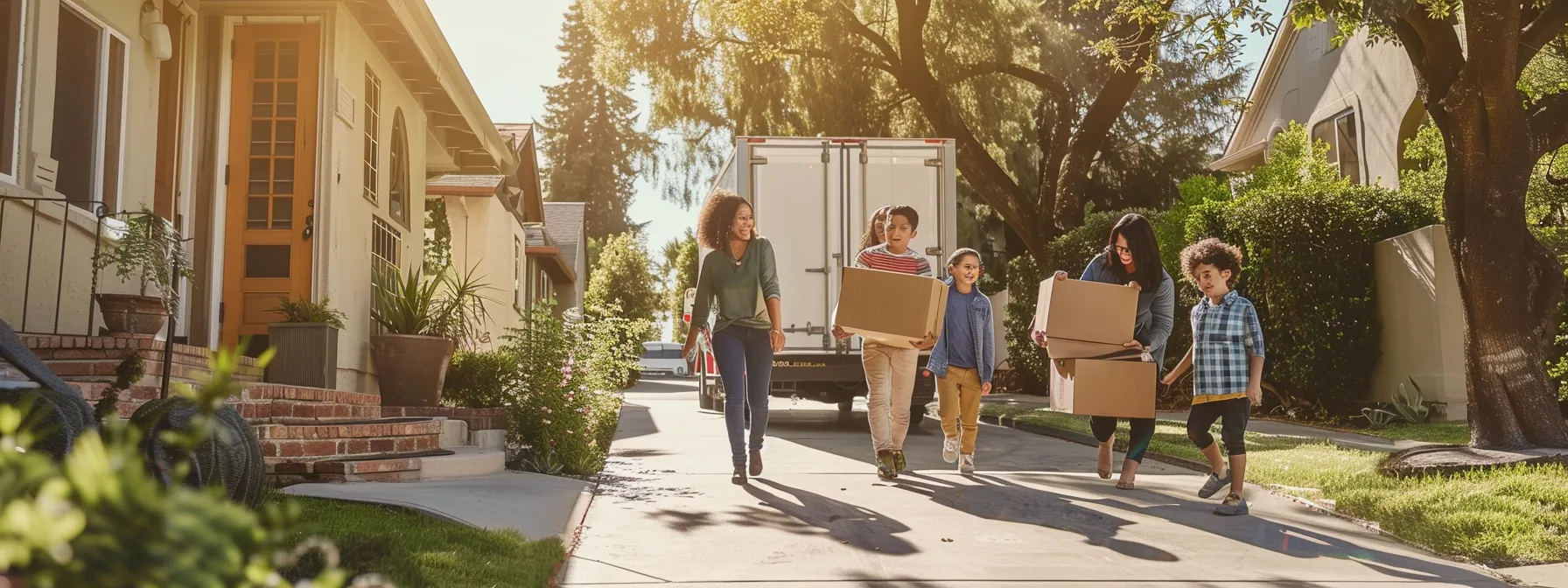 A Family Of Four Smiles As Professional Movers Carry Boxes Into Their Spacious And Bright New Los Angeles Home, With A Moving Truck Parked Outside In A Tree-Lined Neighborhood.