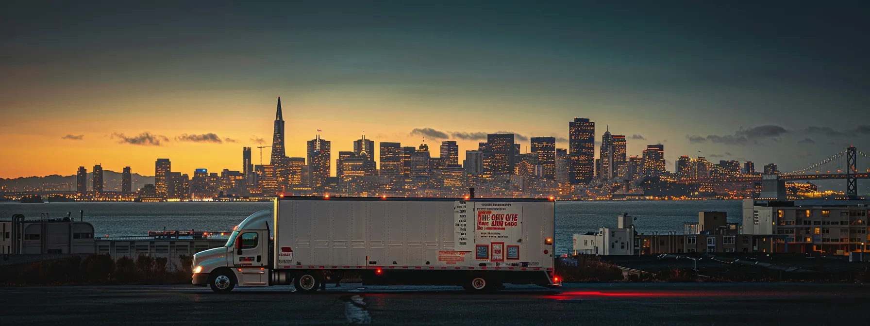 A Professional Moving Truck Parked In Downtown San Francisco With The City Skyline In The Background, Displaying Various Licenses And Certifications On Its Side.